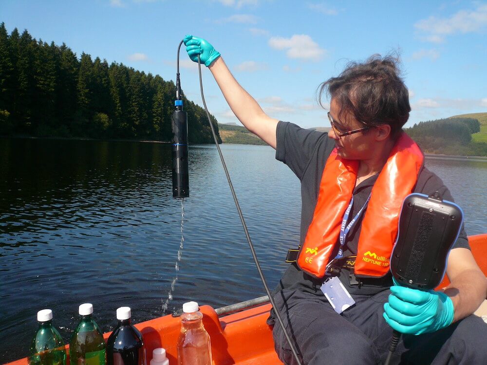 Person in a Boat Holding Water Monitoring Equipment