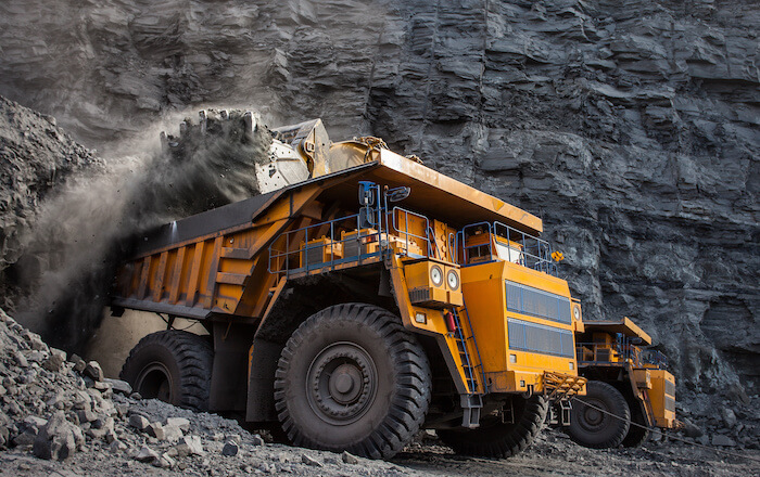 A large yellow mining truck driving down a coal mine