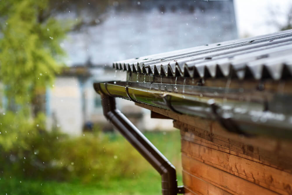Rain flowing down a corrugated roof into the gutter