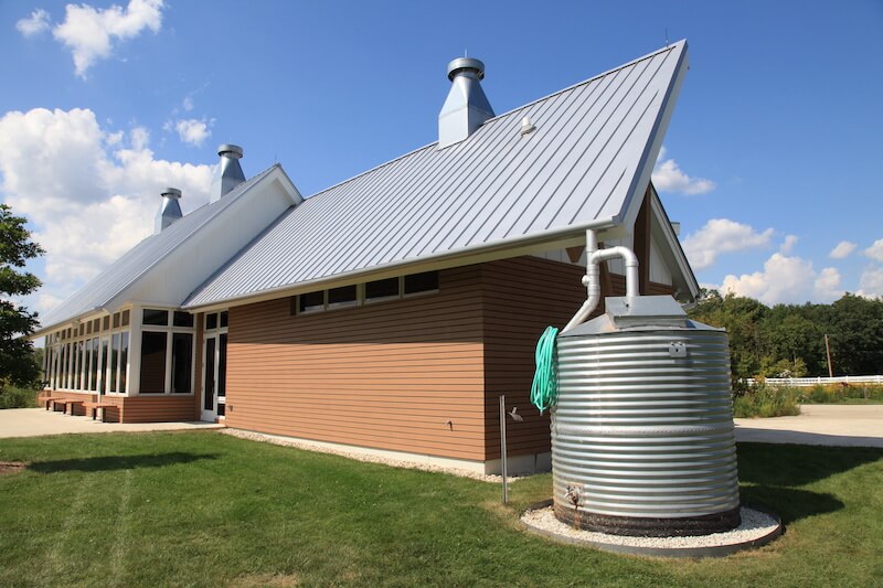 The outside of a modern cistern water collection system next to a new building