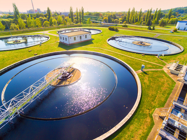 A sewage treatment plant in the EU, surrounded by trees.