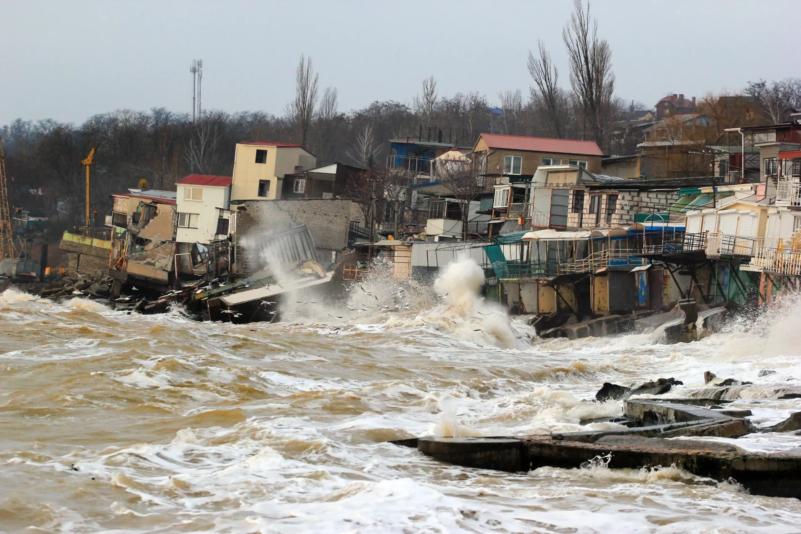 Rising sea levels have caused coastal erosion in a town, causing houses to fall into the water.