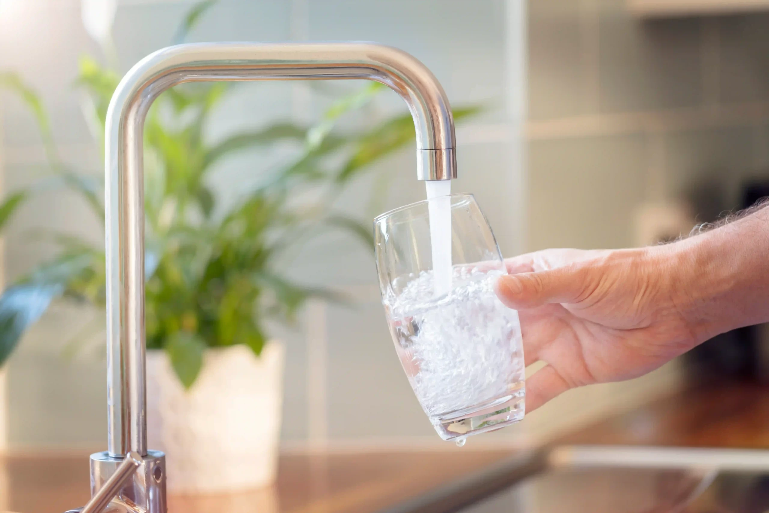 A tap pouring water into a glass.